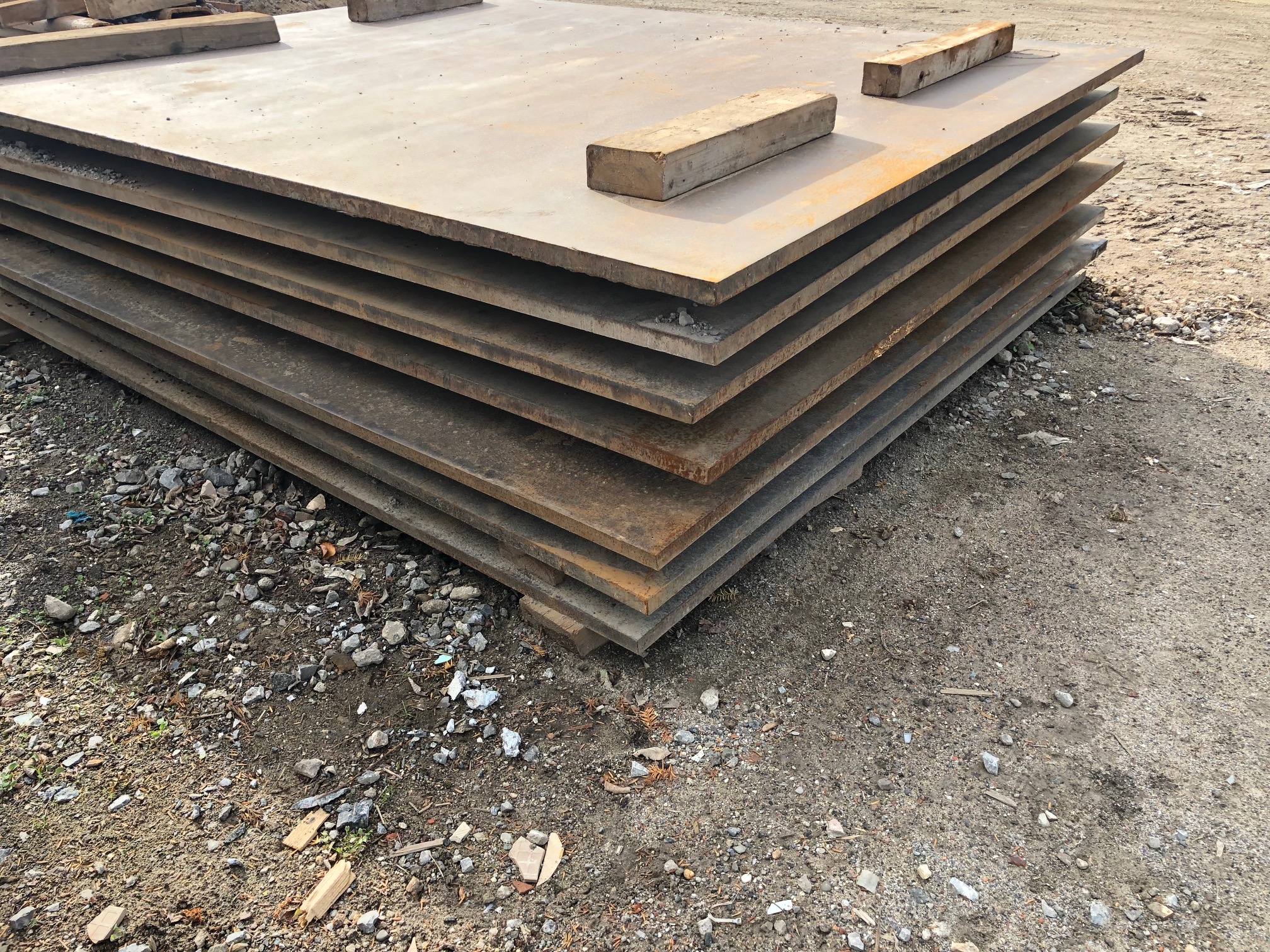 kranplatte-stahl-mieten Stahlplatten aus Stahl mit der Größe von 90c90cm zur Miete auf einem Stapel von 7 Stück.